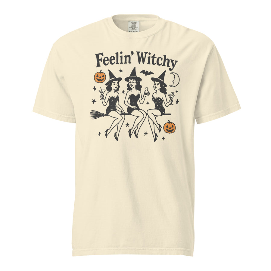 Witchy Halloween heavyweight tee — 'Feelin' Witchy' script above three witches on brooms. Unisex graphic t-shirt, a great witchy gift.