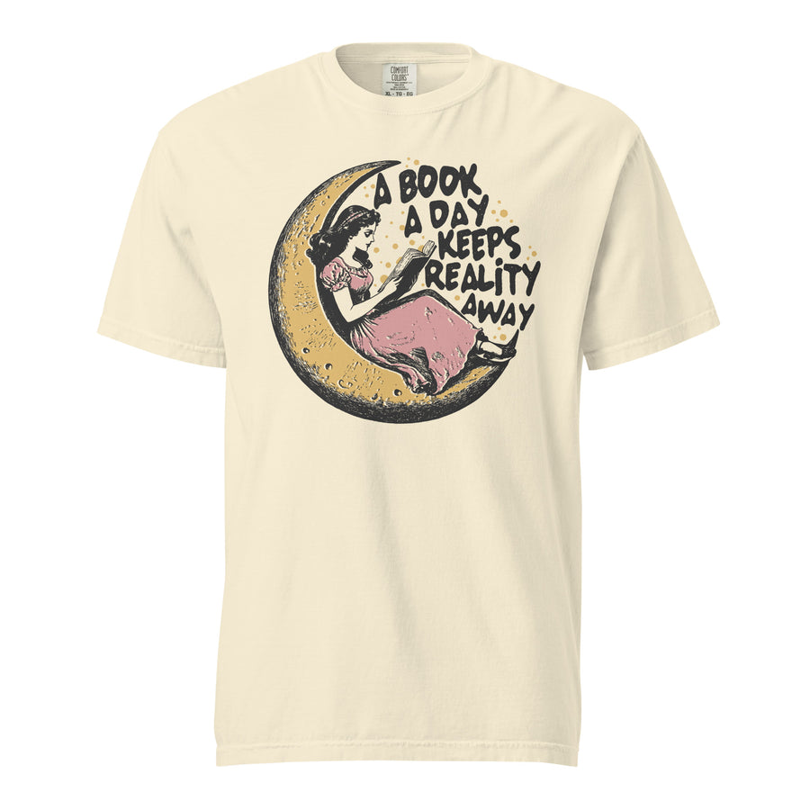 Book lover heavyweight tee — girl reclining on a crescent moon with a book. Unisex graphic t-shirt, a great book-lover gift.